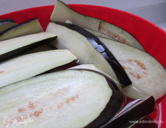 Баклажаны вымыть. Нарезать вдоль пластинами. Вымочить минут 30 в подсоленной воде. Воду слить. Промыть баклажаны в холодной воде и обсушить.