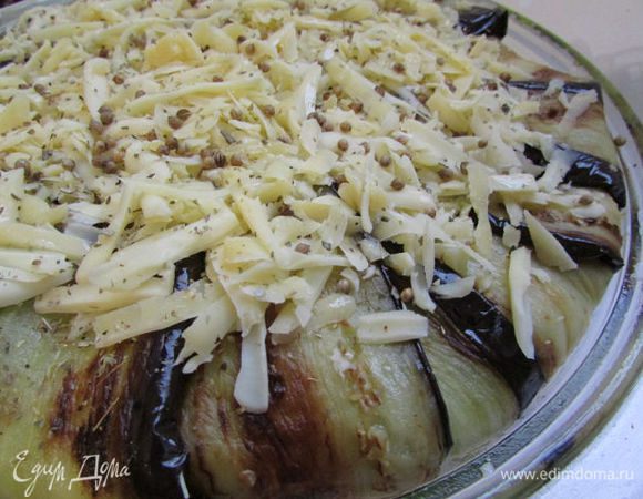 Помидоры накрыть баклажанами (концы пластин завернуть наверх), подлить чуть водички (у меня бульон) , можно и не подливать, т. к. помидоры дадут свой сок, сверху выложить сыр, посыпать кориандр и  травки (у меня орегано).  И готовить в течение 1 часа (+\- зависит от духовки) при 160 С.