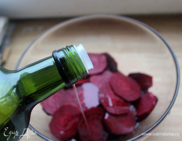Ломтики свеклы выложить в глубокую чашку и полить оливковым маслом. Хорошо перемешать, чтобы свекла со всех сторон была покрыта тонким слоем масла.