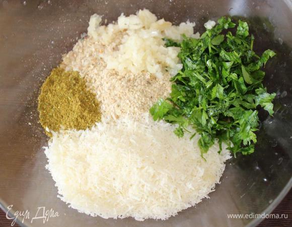 Смешать в миске хлебную крошку (я измельчила подсохший зерновой хлеб с отрубями), рубленые орехи, измельченную петрушку, давленый чеснок, тертый сыр (у меня пармезан) и любимые специи. Я в этот раз добавила хмели-сунели.