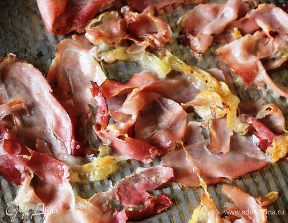 Полоски бекона можно поджарить на сковороде, запечь в микроволновке пару минут на высокой мощности, положив на салфетку и накрыв другой. А можно как я подержать под грилем в духовке при максимальной температуре до хрустящей корочки буквально две минутки.
Затем порвем бекон на произвольные кусочки.