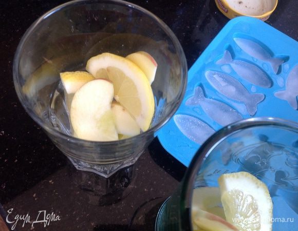 Положите в стаканы лед, дольки лимона и яблока...