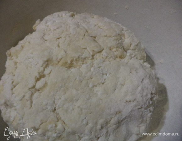 Охлаждённое сливочное масло натереть на крупной тёрке, добавить муку, просеянную вместе с разрыхлителем. Порубить ножом в крошку.
Добавить творог, соль, влить холодную воду и замесить мягкое эластичное тесто. Положить на 30 мин в холодильник.