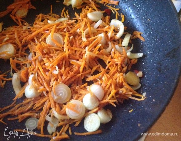 Влить оставшееся масло на сковороду, нагреть на сильном огне до дымка, положить лук и морковь и обжаривать, помешивая, 2 минуты