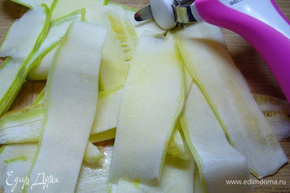 Цукини (кабачок) нарезать на длинные слайсы с помощью овощечистки. Салат вымыть, высушить.