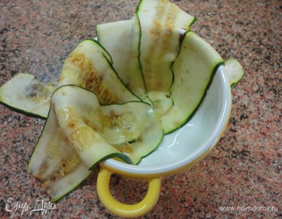 Форму для запекания слегка смазать растительным маслом и выстлать кабачками внахлест.