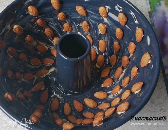 Смазать форму для кекса (24см) маслом и выложить аккуратно оставшийся миндаль.