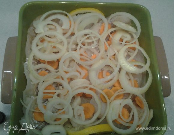 Выложить лук и морковь на рыбу.