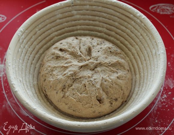 Расстоечную корзину  присыпать мукой выложить тесто швом вверх, накрыть пленкой и оставить на 40-60 минут при 30 С. Если нет корзины, кладем хлеб на противень швом вниз.