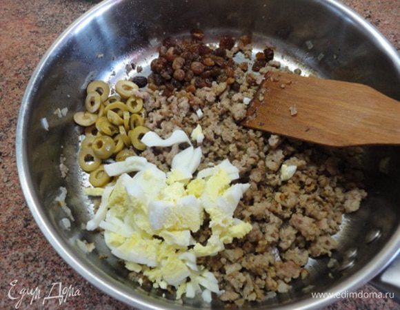 Яйцо отварить вкрутую и мелко порубить. Оливки нарезать кольцами. Изюм промыть, отжать воду. Все добавить в фарш.