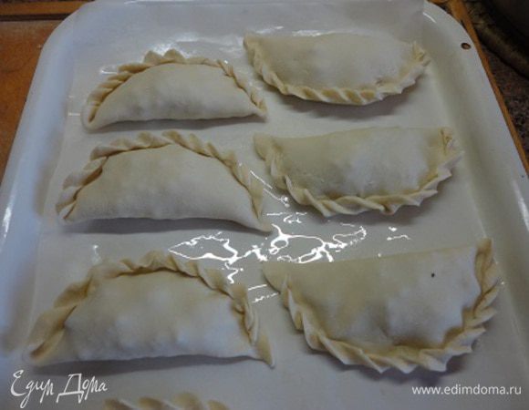 Духовку разогреть до 200 градусов, выложить эмпанадас на противень, смазать молоком.