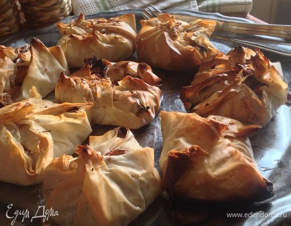 Положить перед собой один квадрат теста, кисточкой смазать одну его сторону растопленным маслом, на него уложить еще квадрат, опять смазать, сверху еще один-у этого смазать только края. В центр положить часть начинки и защипнуть так, чтобы получился мешочек. Снаружи тоже смазать его растопленным маслом. Положить на противень. Проделать ту же процедуру с остальными квадратиками теста и начинкой.  
Выпекать в разогретой до 200 градусов духовке примерно 20 минут. 