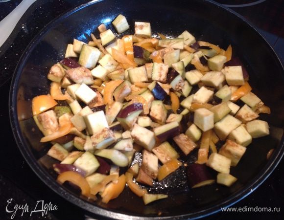 Баклажаны нарежьте кубиками, болгарский перец тонкими полосками. Обжаривайте на той же сковороде 5-7 минут, пока баклажаны не подрумянятся.