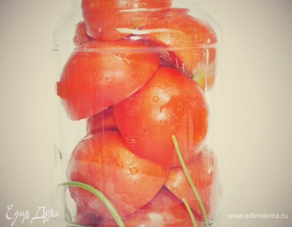 На дно вымытой и стерилизованной банки кладем по 1 листочку лаврового листа, 5 веточек петрушки и по 3 зубчика чеснока. Помидоры разрезаем на половинки и укладываем разрезом вниз.