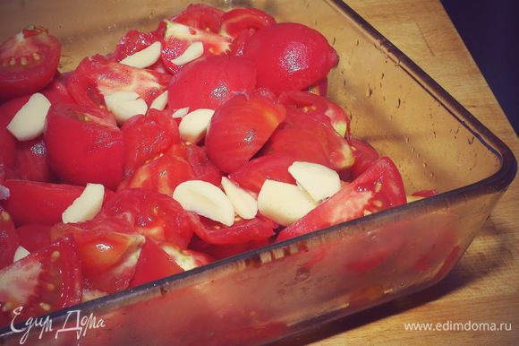 Режем помидоры дольками, складываем в форму вместе с крупно порезанным чесноком. Запекаем в духовке при 180 градусов примерно 40 - 45 минут.