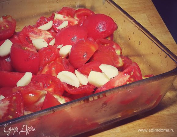 Режем помидоры дольками, складываем в форму вместе с крупно порезанным чесноком. Запекаем в духовке при 180 градусов примерно 40 - 45 минут.