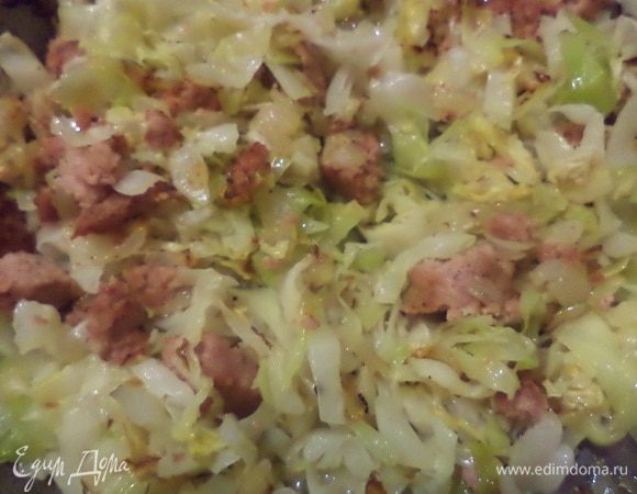 Луковицу мелко нарезать и обжарить на растительном масле до прозрачности.
Ветчину нарезать тонкими ломтиками, выложить к луку и обжарить.
Добавить капусту, протушить всё вместе под крышкой на небольшом огне.
