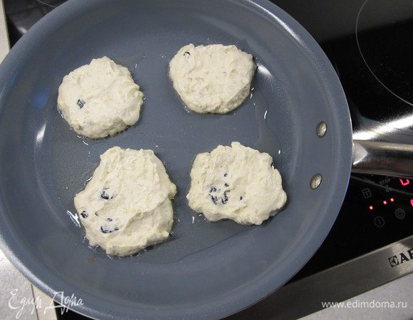 С помощью ложки выложить сырники на разогретую сковороду и обжарить на умеренном огне с одной стороны до золотистой корочки.