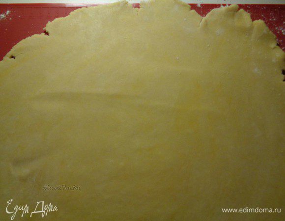 Посыпим силиконовый коврик мукой. Также обваляем в муке сталку и верх теста. Раскатаем ровный по толщине пласт, примерно 28 см. в диаметре.