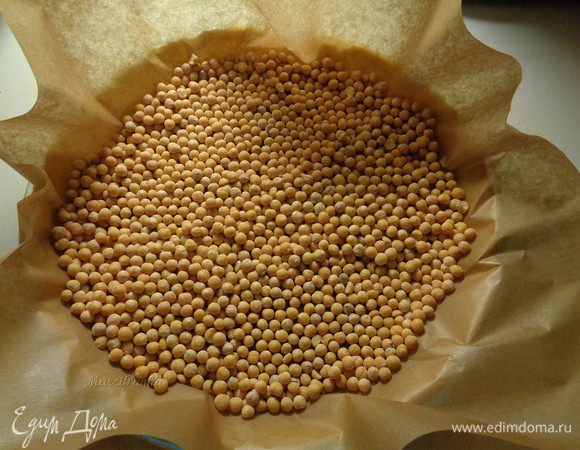 Положим сверху теста пекарскую бумагу и насыпем горох сверху. 