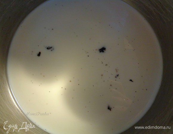 Нальем в кастрюльку молока. Стручек ваниль разрежем вдоль острым ножом и с половинки выскребем зернышки ванили, которые затем добавим к молоку. Включим огонь и доведем молоко до кипения.