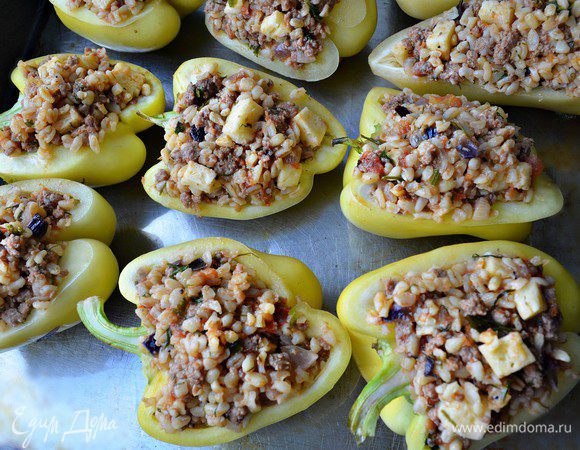Половинки перцев наполнить фаршем, выложить на смазанный растительным маслом противень. Запекать перцы около 30 мин в нагретой до 180 г духовке.
