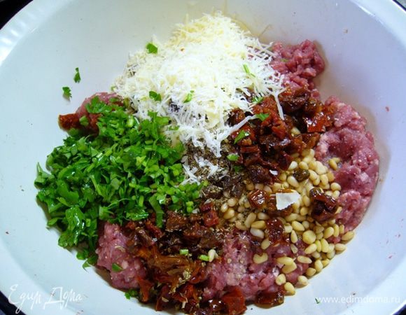 Вяленые помидоры измельчить. Петрушку мелко порезать. Пармезан натереть.
Соединить фарш, сухари, кедровые орехи, лимонную цедру, изюм (с уксусом), орегано, вяленые помидоры, петрушку (немного оставить для подачи), половину пармезана. 
Посолить и хорошо перемешать.
