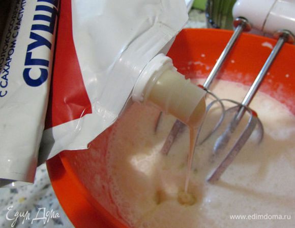 Продолжая взбивать, ввести тонкой струйкой сгущенку.