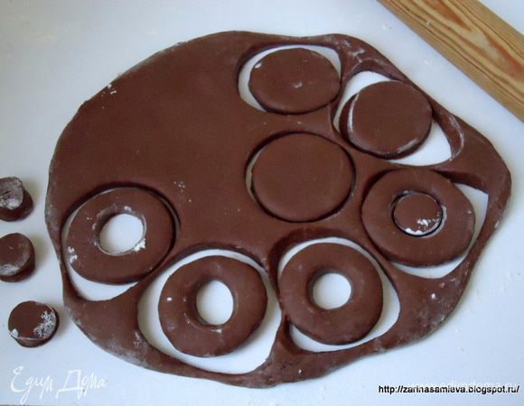 После, для удобства разделки теста, разделить его на три – четыре части, раскатать в пласт 1 см толщиной и вырезать пончики диаметром 8 см, а так же серединки меньшего диаметра.