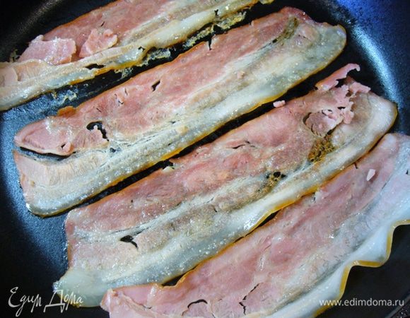 Бекон обжарить на сухой сковороде до хруста, поместить на бумагу для выпечки, сбрызнуть кленовым сиропом, остудить.