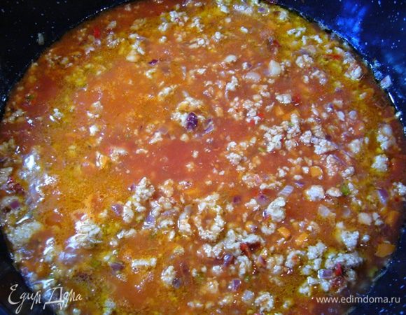 С замоченного перца чили слить воду (воду сохранить). Тонко нарезать перец чили (семена я также удалила) и вмешать в овощную массу вместе с фаршем.
Обжаривать 5 мин., разбивая комочки фарша. 
Влить воду, в которой замачивали перец, добавить протертые томаты (Passata), посолить, довести до кипения.
Убавить огонь и тушить 1 ч. до загустения.
