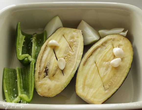 Нагреть духовку до 180-200 гр. 
Баклажан порезать вдоль на 2 части, смазать со всех сторон оливковым маслом и уложить на противень. Запекать 25-30 минут.
Лук почистить и порезать на дольки . Сладкий перец очистить и порезать на  части . Смазать кусочки лука, перца и чеснок  оливковым маслом со всех сторон и положить рядом с баклажаном. 