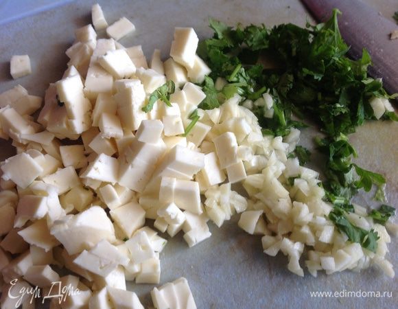 Духовку разогрейте до 200 градусов. 

Зелень и чеснок мелко порубите. Сыр порежьте маленькими кубиками. Перемешайте.