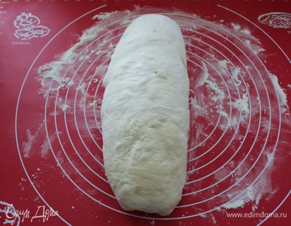 Подошедшее тесто выкладываем на стол. Формируем из него батон. Выкладываем на противень с пекарской бумагой и оставляем на 45-60 минут