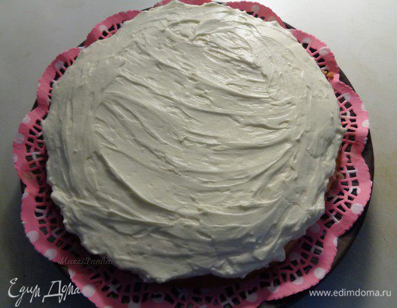 Покроем бисквитный корж кремом, аккуратно распеределив его по всей поверхности.
