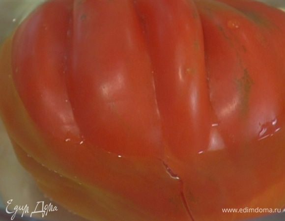 Красный помидор надрезать крест-накрест, залить кипятком, дать немного постоять, затем обдать его холодной водой и снять кожицу.