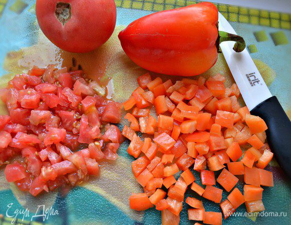 Томаты нарезать крест-накрест, обдать кипятком и очистить от кожицы. Нарезать томаты и болгарский перец кубиками.