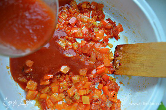 К луку добавить порезанные помидоры и болгарский перец, тушить 7 мин. Затем влить томатный соус, приправить солью, перцем и довести соус до кипения.
