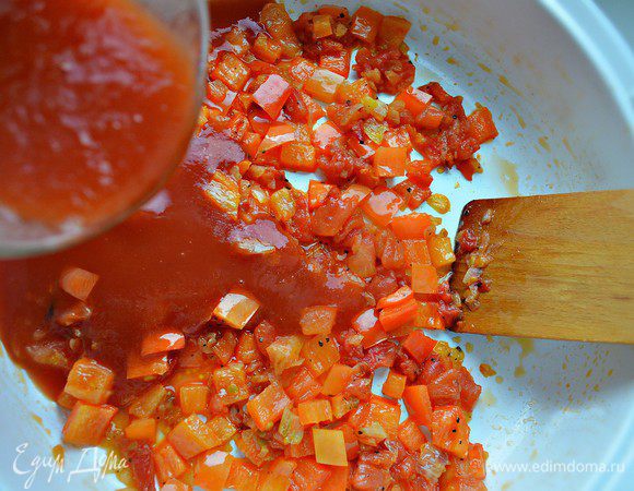 К луку добавить порезанные помидоры и болгарский перец, тушить 7 мин. Затем влить томатный соус, приправить солью, перцем и довести соус до кипения.