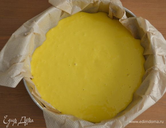 Форму для выпечки (диаметр 24 см) застелить пекарской бумагой и выложить тесто.