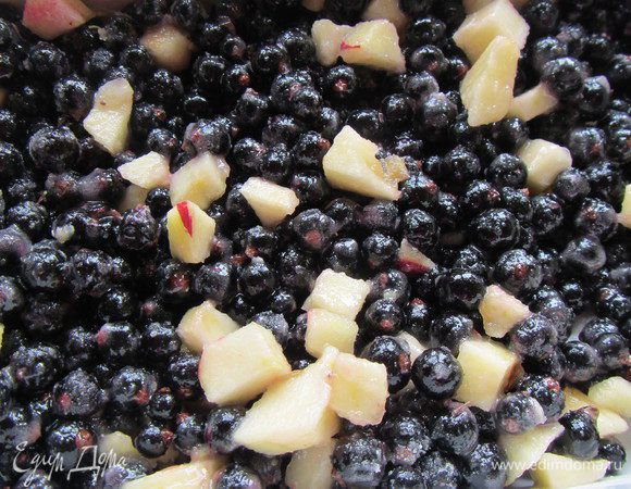 У черной смородины удаляем стебельки и добавляем ее к яблоку. Всыпаем сахар и муку. Все перемешивем и выкладываем в форму для запекания.
