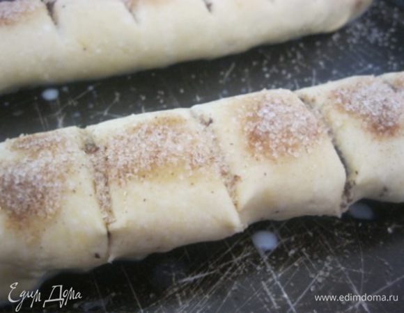 Свернуть тесто с начинкой в плотный рулет, переложить в форму.
Острым ножом сделать 10-12 надрезов на 3/4 глубины теста.
Смазать рулеты молоком и посыпать сахаром с корицей.
Выпекать в разогретой духовке до 180 С духовке, минут 30-35.