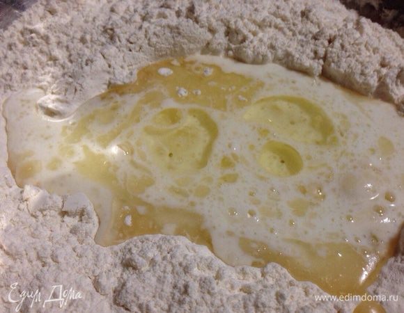 Сделать в муке небольшую ямку и влить кефирно-масляную массу.
