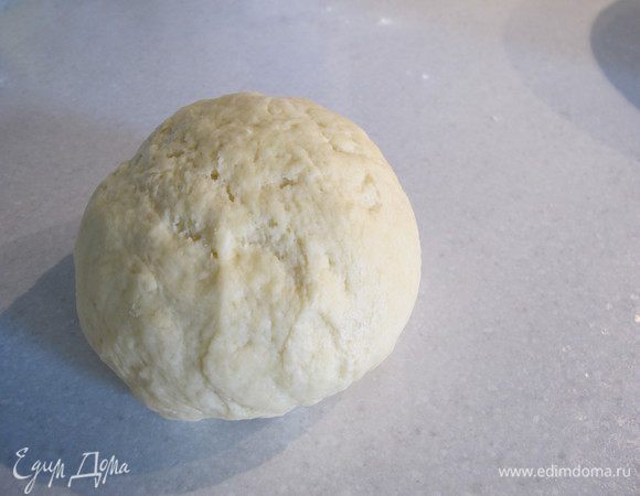 В получившуюся массу добавить сахар, соду и просеянную муку. Замесить тесто, скатать его в шар и поставить в холодильник на 1 час.