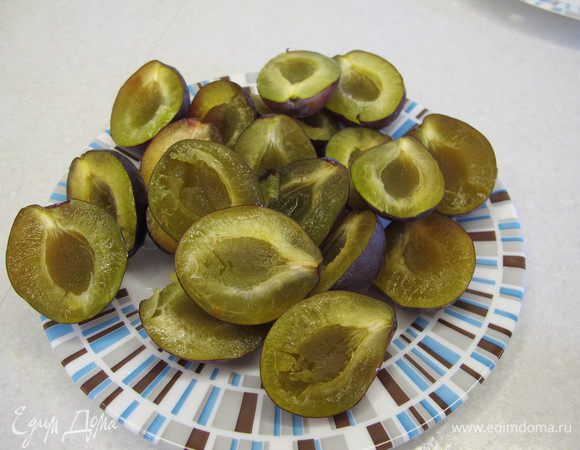 Сливы разрезать пополам и удалить косточки.