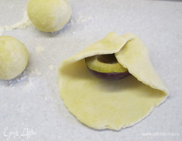 Заворачиваем в лепешки половинки слив, затем печенье обмакиваем в растительное масло и сахар и выкладываем на пергамент, смазанный маслом (или на коврик для выпечки). Печенье наколоть вилкой.