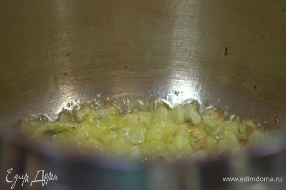 В кастрюле с тяжелым дном разогреть 2–3 ст. ложки оливкового масла и сливочное масло и обжарить лук и чеснок.