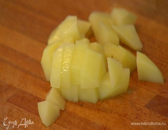Картофель почистить, нарезать небольшими кубиками и добавить в кастрюлю, все перемешать, затем влить горячий овощной бульон.