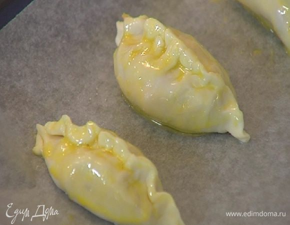 Противень выстелить бумагой для выпечки, смазать ее оливковым маслом, выложить пирожки и выпекать в разогретой духовке 20 минут.