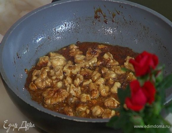 В отдельной сковороде разогреть оставшееся сливочное масло, всыпать оставшийся сахар и выложить орехи, слегка поломав их руками. 